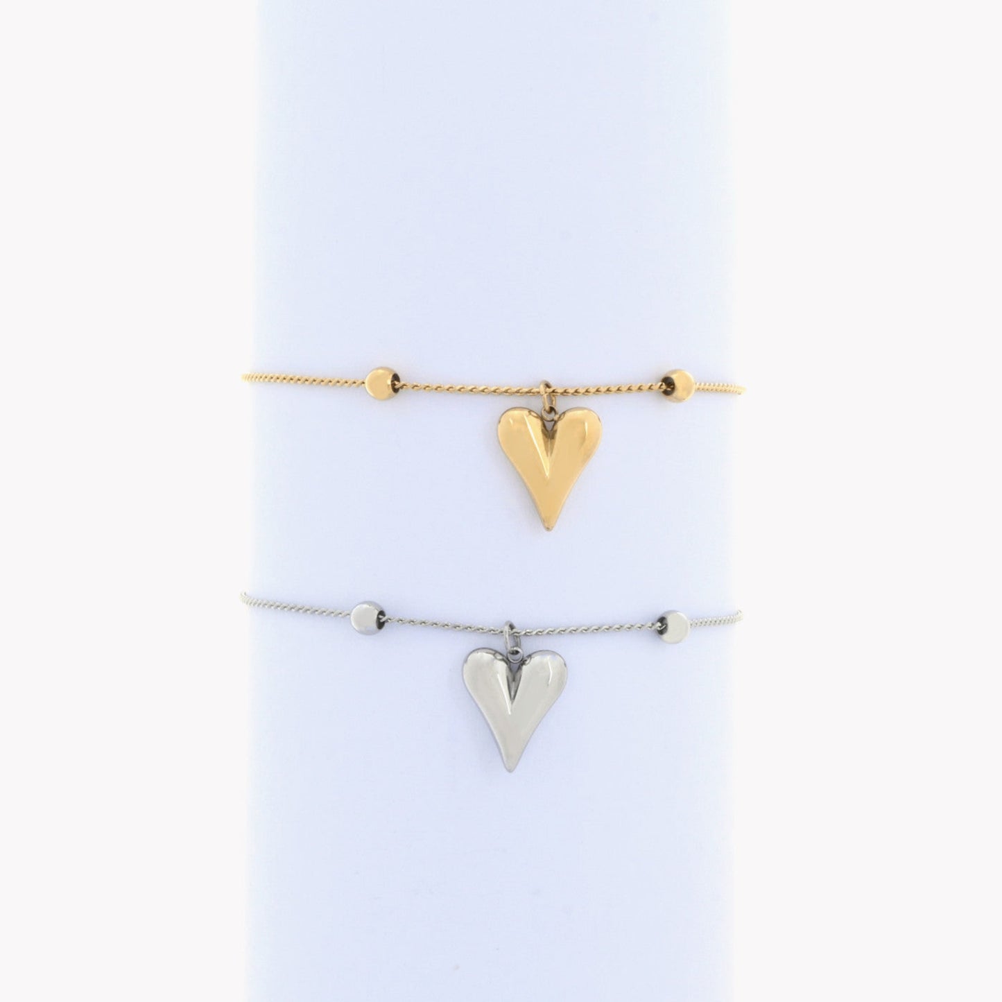 Uma foto de Pulseira Aço com Coração pendente dourado em cima e pulseira aço prateada em baixo - L&L Aço